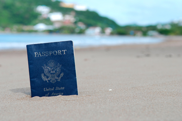 A U.S. Passport stuck in a sandy beach